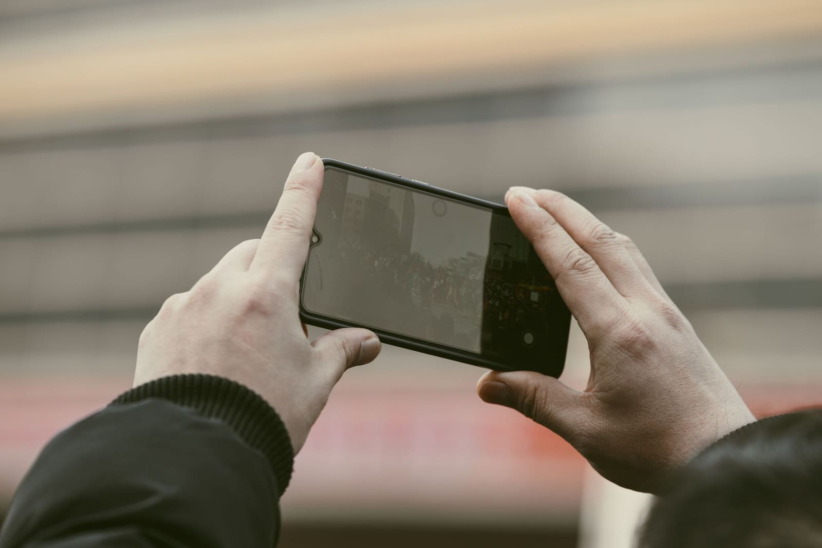 Une main tient un smartphone devant un établi de menuisier couvert de copeaux