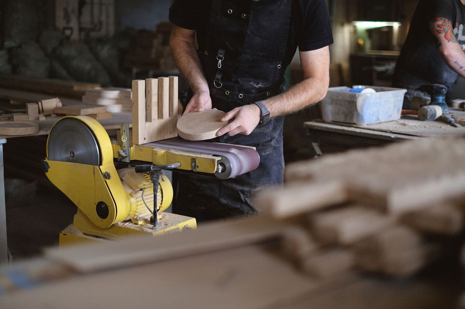 Menuisier au travail dans son atelier, planches de bois et outils sur l'établi