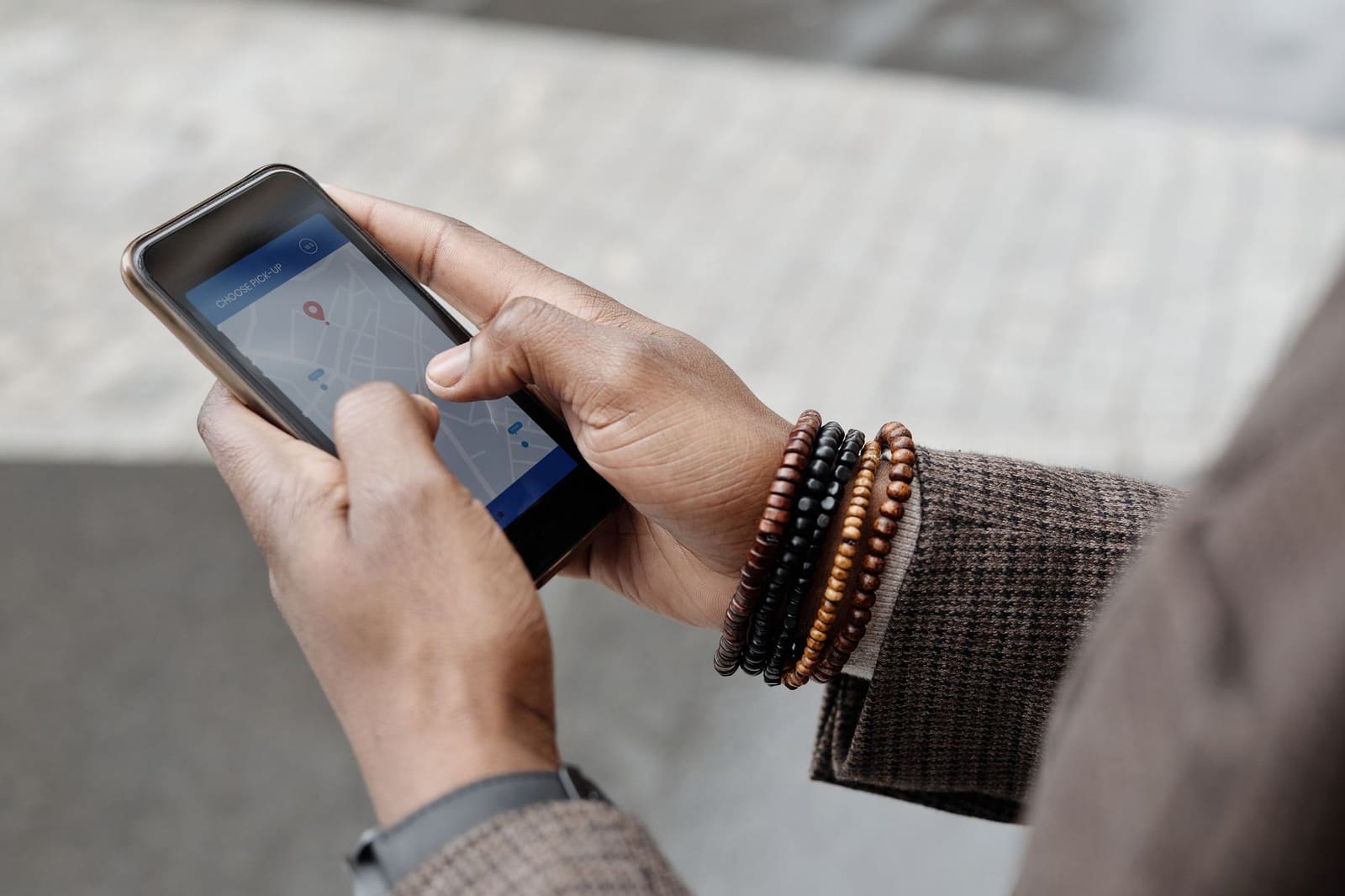Une main tient un smartphone affichant une carte avec plusieurs fiches d'entreprises locales